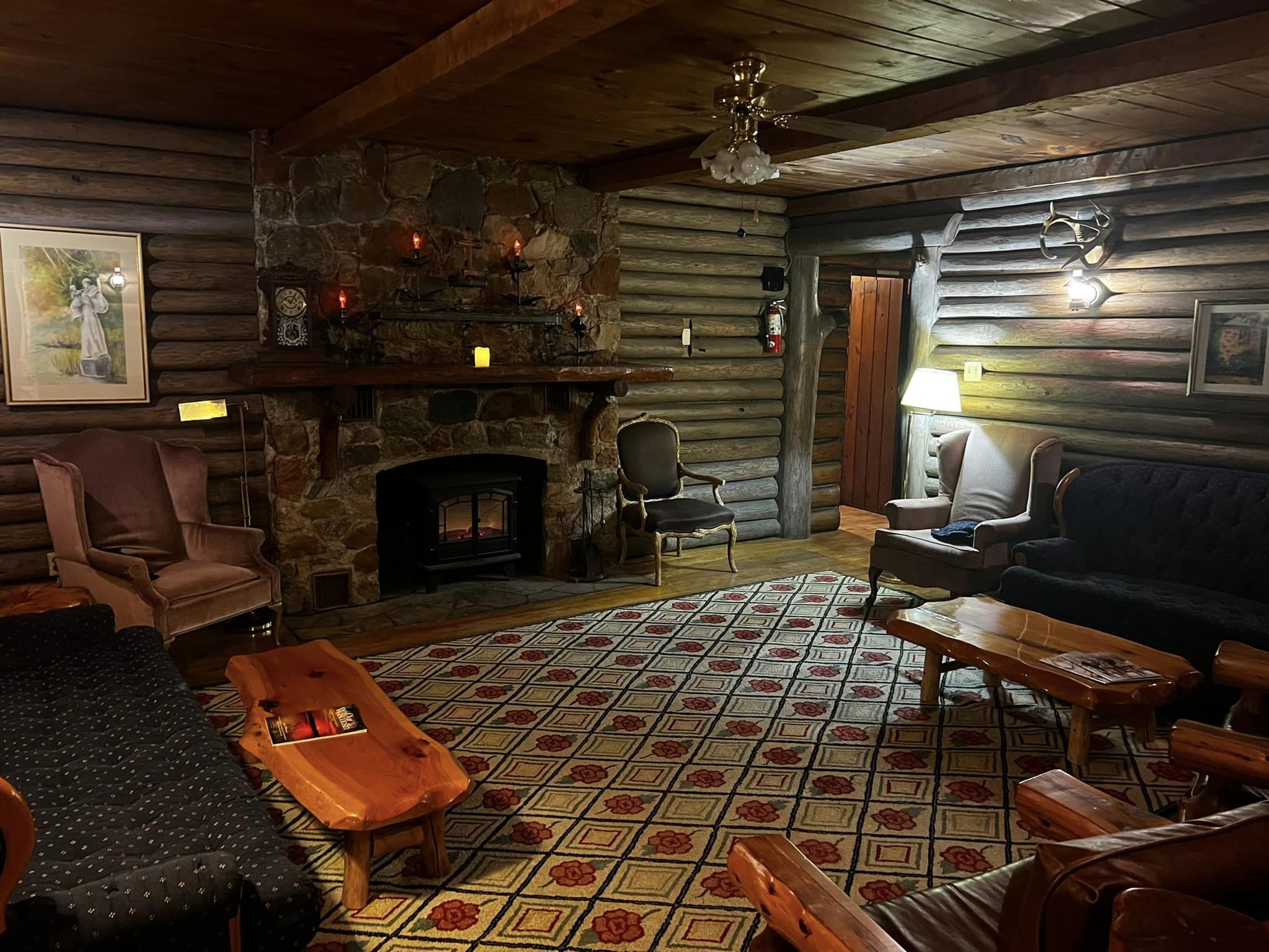 Log Lodge fireplace sitting room with stone fireplace and rustic furnishings